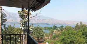 A balcony with a view of a lake and mountains. - Divine Stay Inn Resort  (Wai)