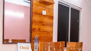 Et træspisebord med stole, et spejl og et skilt med teksten 'Omji'.