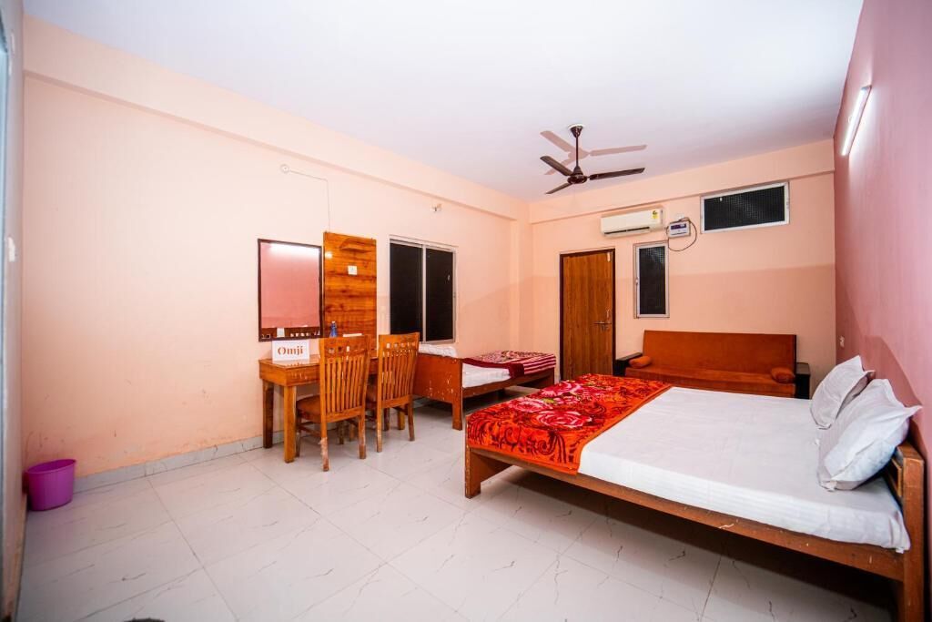 Une chambre à coucher comprenant un lit, un bureau, une chaise, un ventilateur de plafond et un appareil de climatisation.