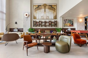 A spacious lounge area with modern furniture, a bar, and decorative wall art. - Prime Domus Brickell 2BR Condo (Miami)