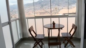 Ein Balkon mit Blick auf eine Stadtlandschaft und Berge.