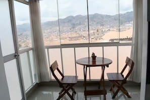 Ein Balkon mit Blick auf eine Stadtlandschaft und Berge.