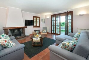 Ein Wohnzimmer mit Kamin, zwei Sofas, einem Couchtisch und einem Fernseher.