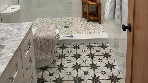 Une salle de bain avec douche, toilettes et lavabo.