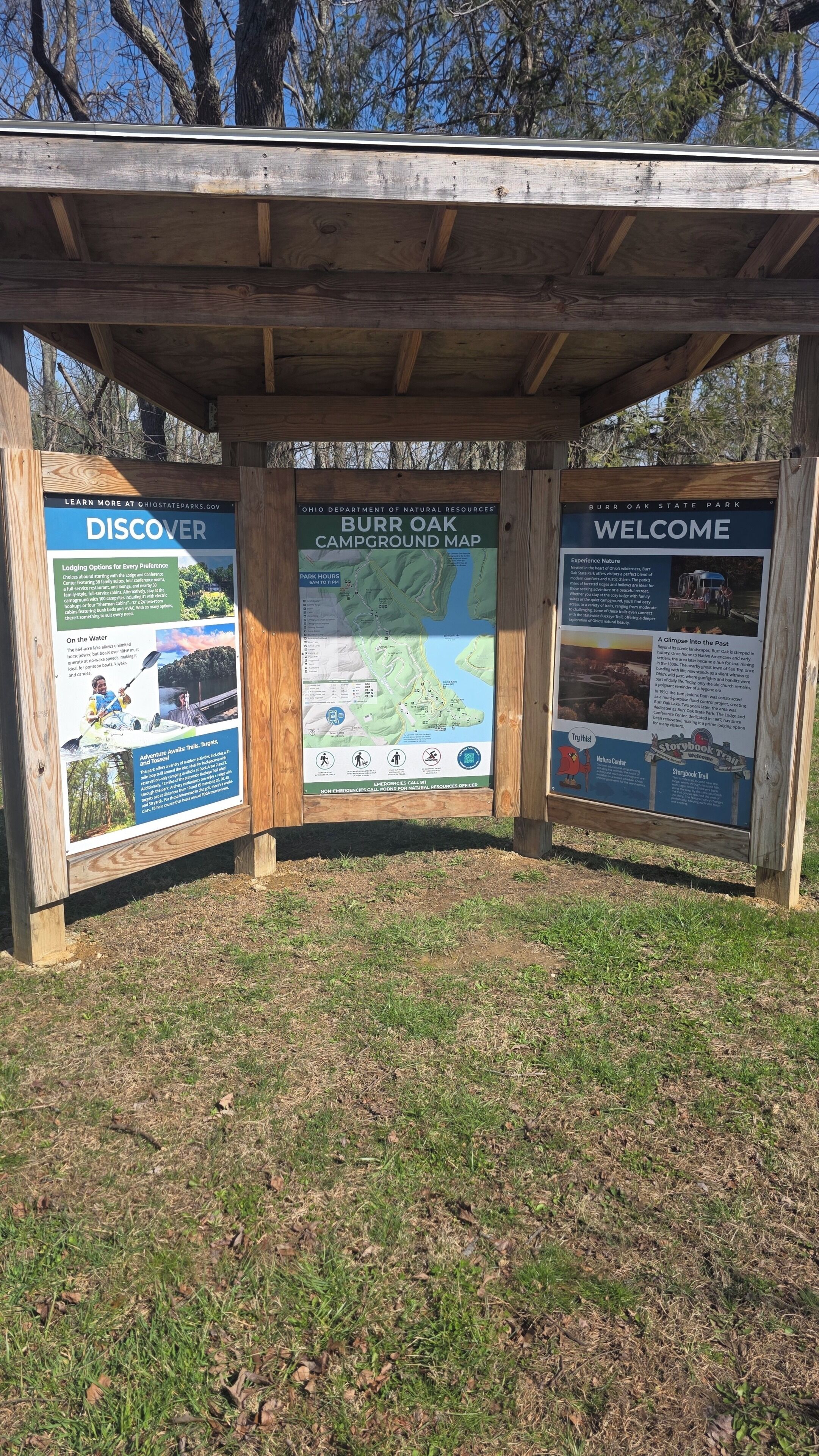 Ein Holzinformationsschild im Burb Oak State Park mit Karten und Informationen für Besucher.