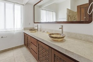 Ein Badezimmer mit zwei Waschbecken, einem großen Spiegel und einem Holzkabinent.