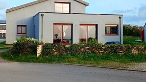 A modern two-story house with large windows, a flat roof, and a visible chimney. - House with sea view, a few steps from the magnificent Gouérou beach. (Lampaul-Plouarzel)
