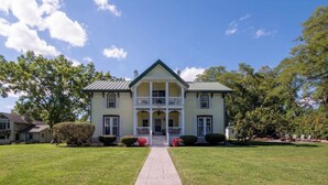 A two-story house with a front porch, a covered walkway, and a well-maintained lawn. - Cayuga Belle: Gorgeous Cayuga Lake Estate! Fabulous Views! (Seneca Falls)
