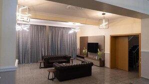 A modern living room with a sofa, a coffee table, and a TV.