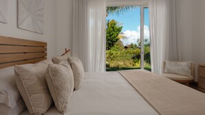 Un dormitorio con una cama grande, cabecera de madera y vista a la vegetación a través de un ventanal.