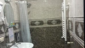 A bathroom with a sink, toilet, shower, and a mirror. - OTEL IVERIA (Stepantsminda)