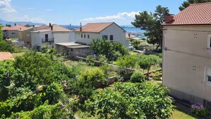 Um bairro residencial com casas, um jardim e vista para o mar.