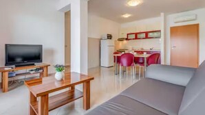 A modern living room with a flat-screen TV, wooden coffee table, and a sofa. - Mise Holiday Apartments - Two bedroom apartment II (Kastel Gomilica)
