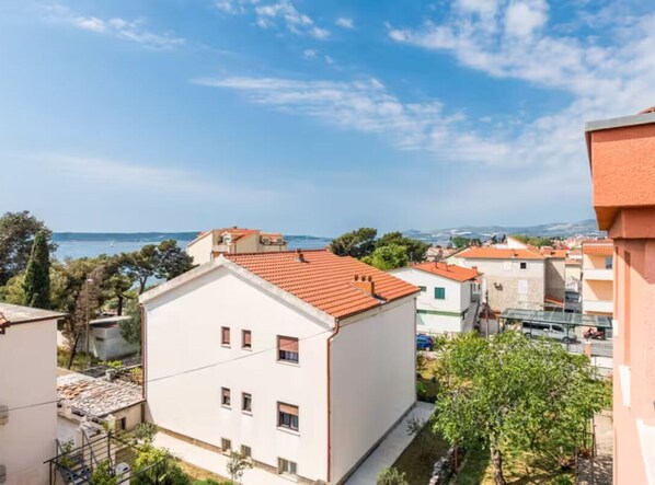 Ett bostadsområde med byggnader, en klar himmel och en avlägsen utsikt över havet.