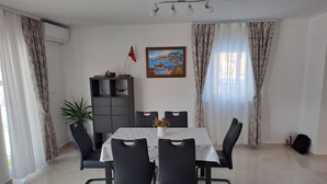 Ein Essbereich mit Tisch, Stühlen, einem Schrank und einer Flagge.