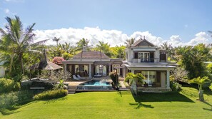 A two-story house with a swimming pool, a covered patio, and lush greenery. - Graceful 4-Bedroom Villa / Infinity Pool & Golf View (Bel Ombre)