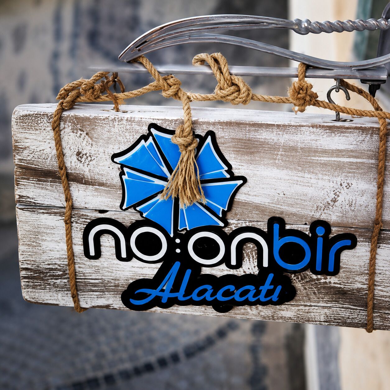 A rustic wooden sign with the text 'no:onbir Alacati' and a blue star graphic.