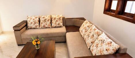 A modern living room with a sectional sofa, a coffee table, and a ceiling fan.