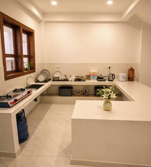 A compact kitchen with a gas stove, sink, and a small window.