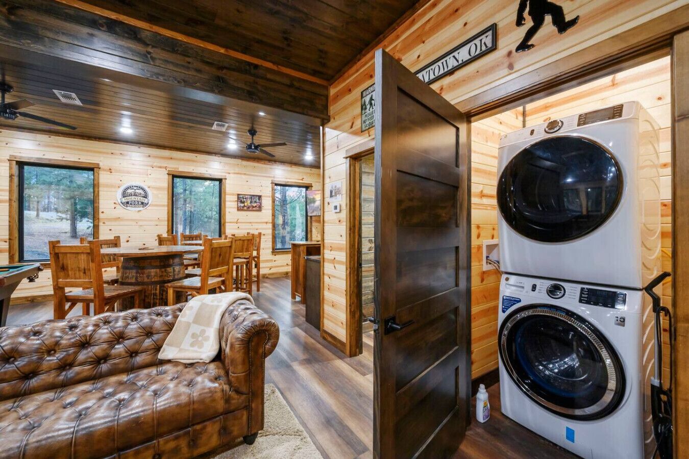 L’intérieur d’une cabine comprenant un coin repas, un canapé et un appareil lave-linge et sèche-linge superposés.