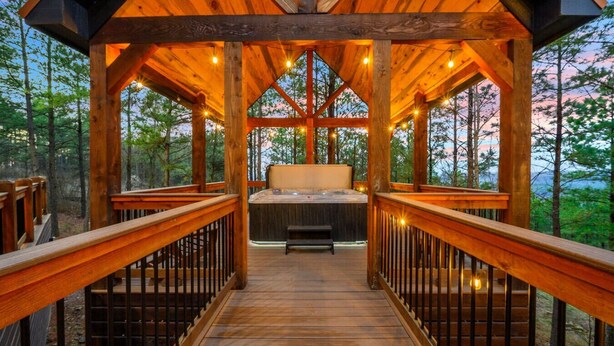 A wooden deck leading to a hot tub with a bench, surrounded by a wooden gazebo with railings. - Swimming Beaver Mansion · Indoor Pool Year-Round, Sleeps 28, Game Room, Views! (Broken Bow)