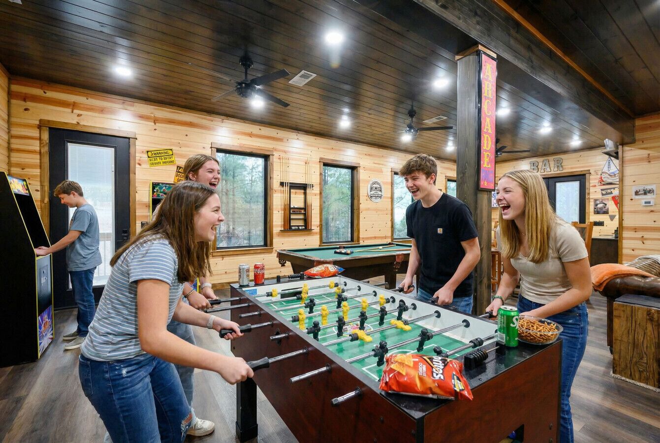 Een houten interieur met een tafelvoetbaltafel, een pooltafel en een bar.