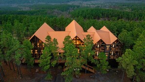 A multi-story lodge with a symmetrical roof design, surrounded by dense forest. - Swimming Beaver Mansion · Indoor Pool Year-Round, Sleeps 28, Game Room, Views! (Broken Bow)