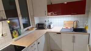 A kitchen with a microwave, toaster, sink, and dishwasher.