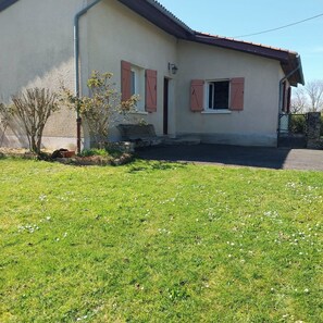 A single-story house with a sloped roof, a small front porch, and a paved driveway. - Le P'tit cosy de Mu (ytrac)