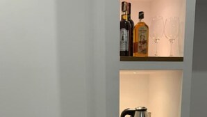 A kitchen with a white refrigerator, a coffee maker, and two cups on the counter. - Vladimir Estate (Gjirokastër)