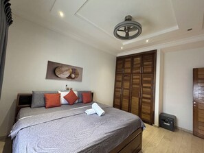 A bedroom with a bed, a ceiling fan, a wardrobe, and a safe. - Ayan Villas  luxurious One bedroom penthouse with a beach view! (Oshiyie)