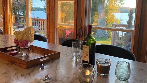 A marble countertop with a bottle of wine, glasses, and a tray.