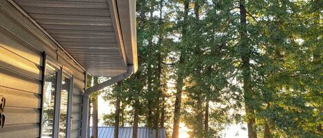 A wooden deck with a railing, a red chair, and a dog.
