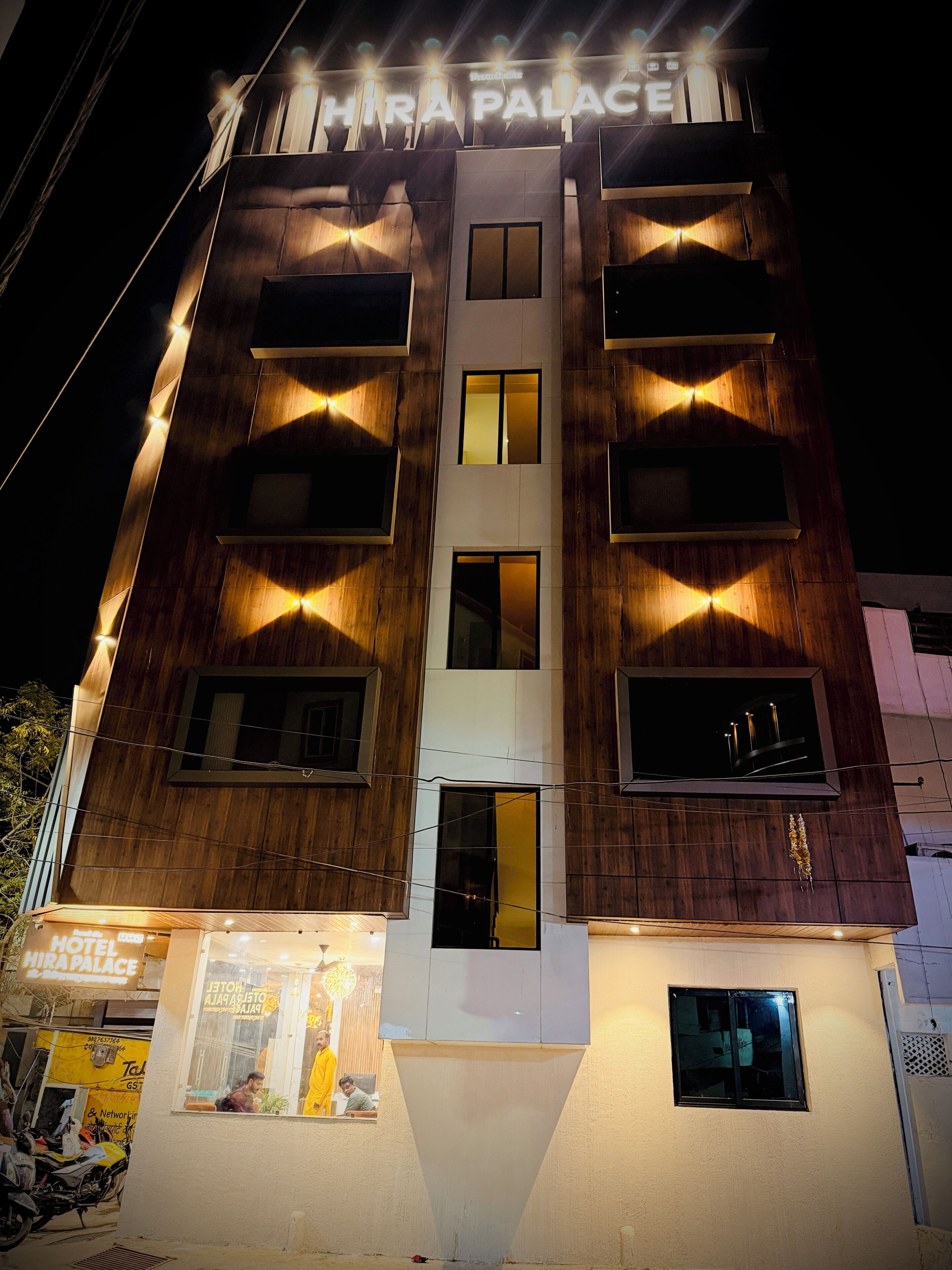 A multi-story building with a sign reading 'HIRA PALACE HOTEL.'