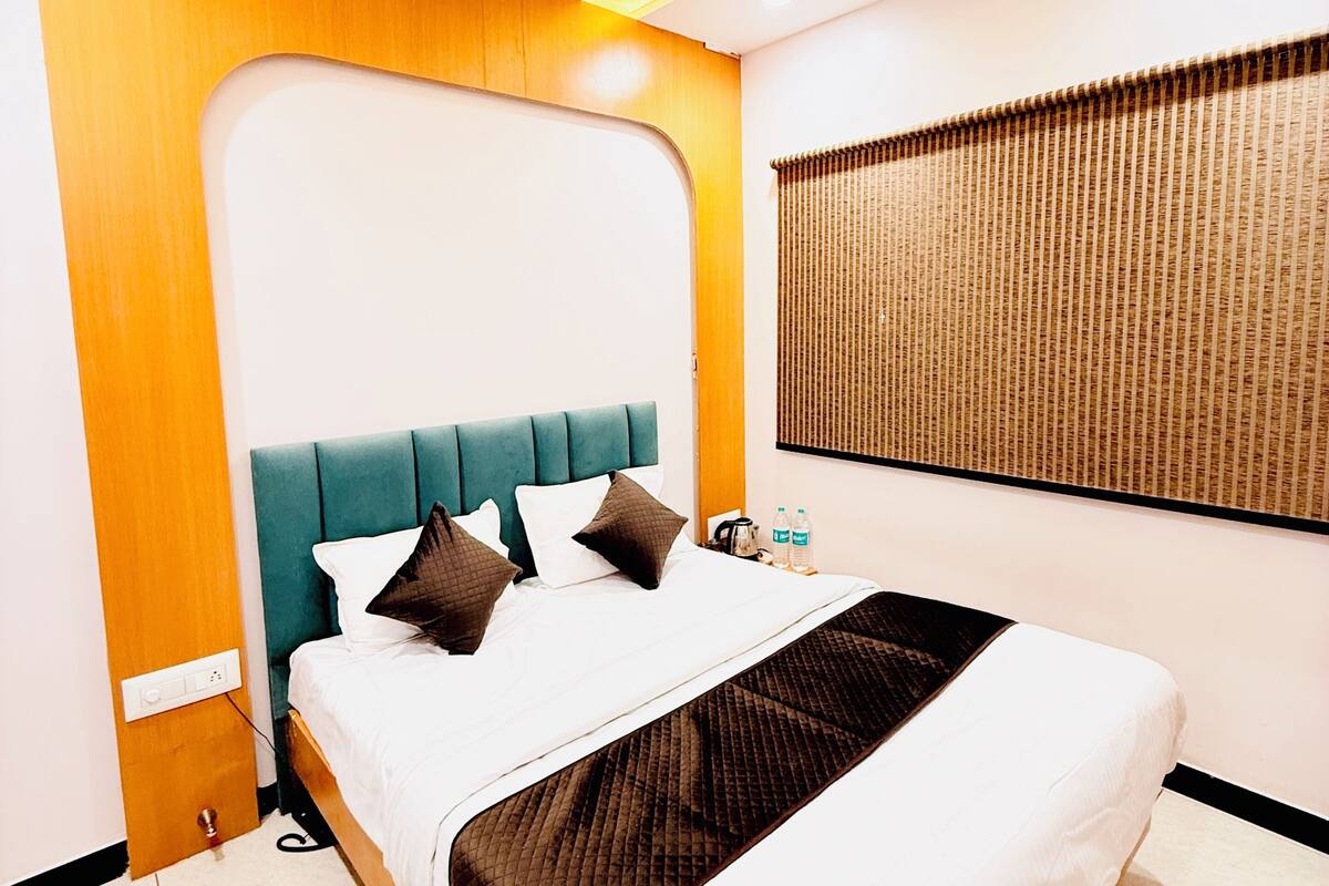 Ein Hotelzimmer mit einem Bett, Deckenventilator, Wandklimaanlage und einem Fenster mit Jalousien.