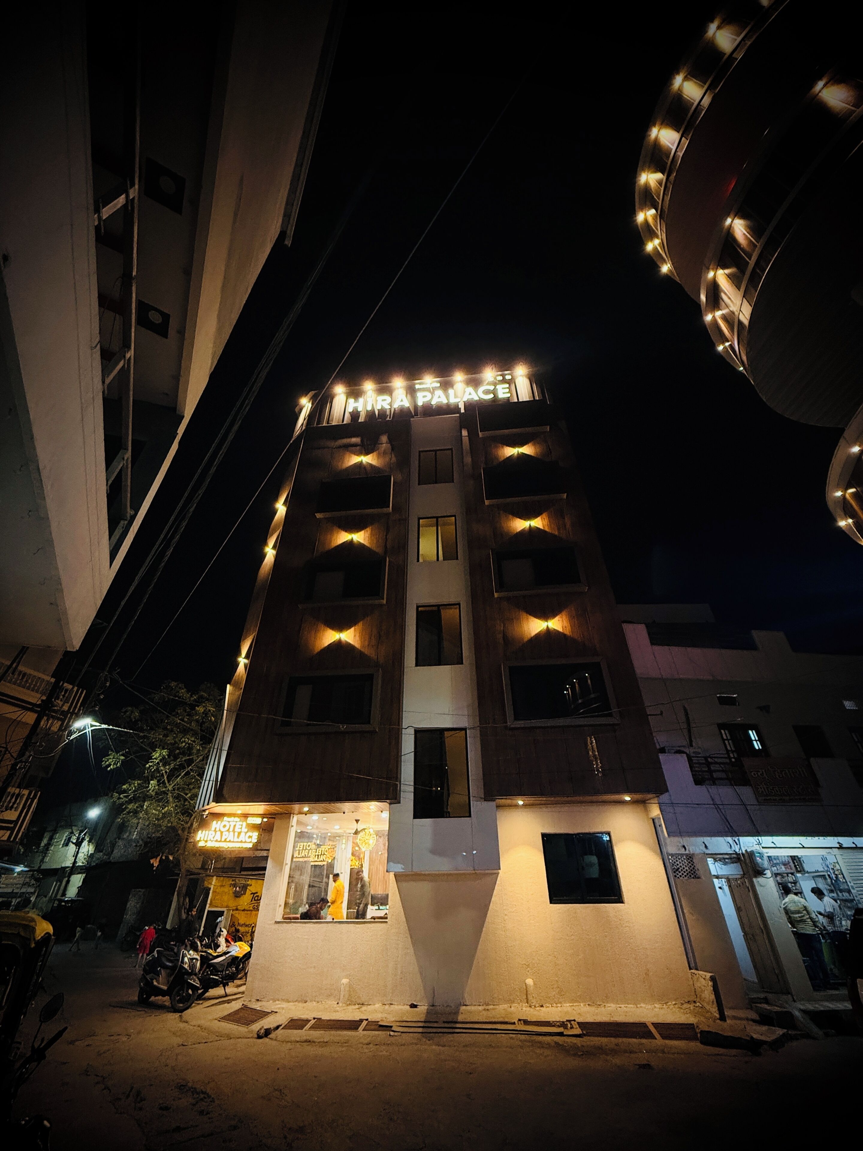 A multi-story hotel with a prominent sign reading 'Hira Palace.'