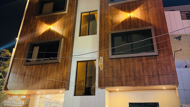 A multi-story hotel with a modern design, featuring a prominent sign at the top. - Hotel Hira Palace (Ujjain)