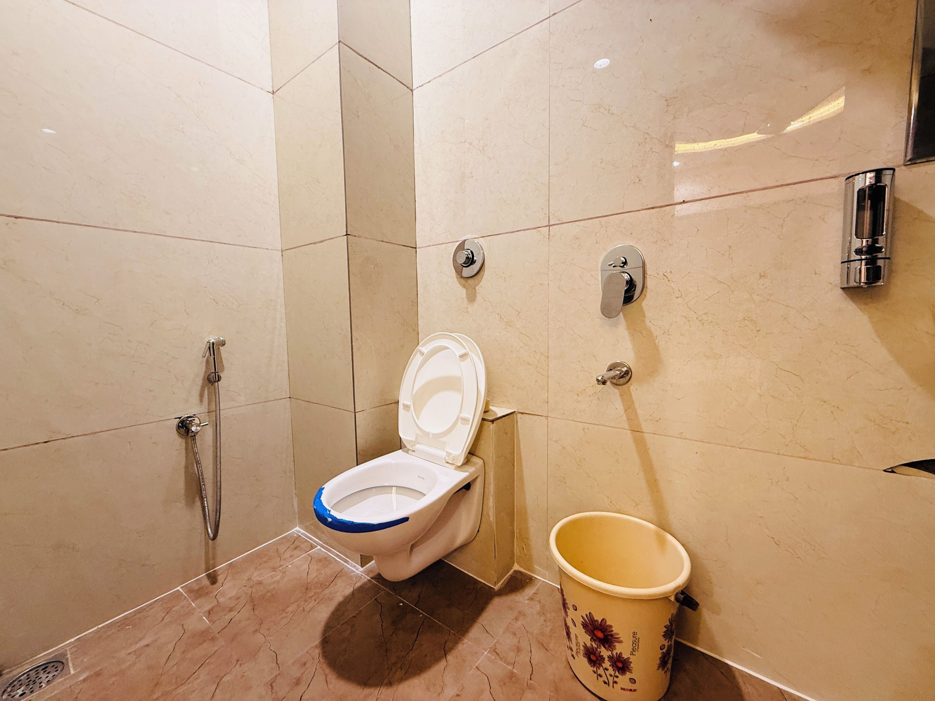 A bathroom with a toilet, bidet, and a trash bin.