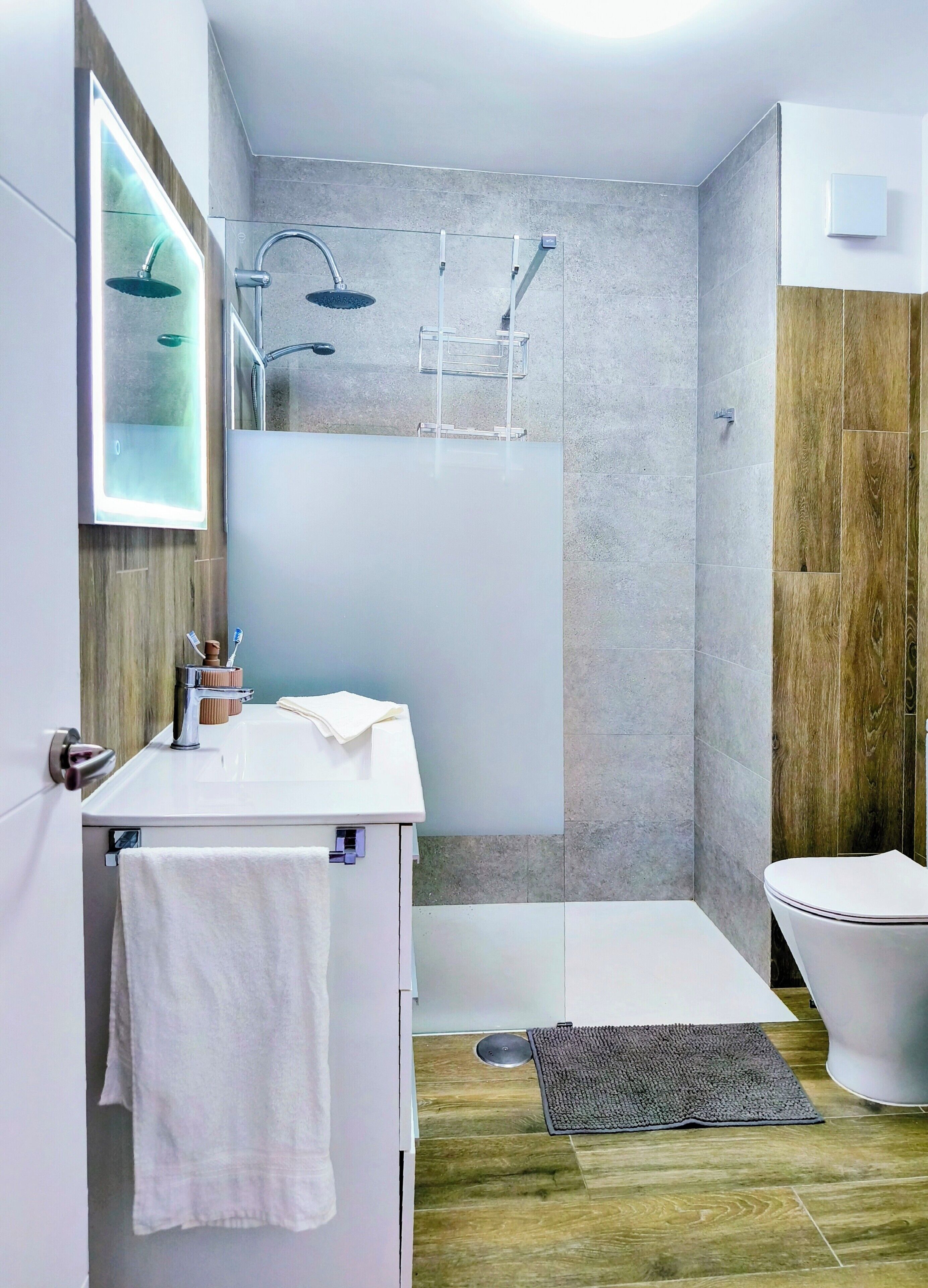 Une salle de bain moderne équipée d’une douche, de toilettes et d’un lavabo.
