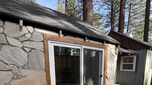 A stone exterior with a sliding glass door leading to an interior space. - Lovely 3-bedroom cottage in South Lake Tahoe perfect for your getaway (South Lake Tahoe)