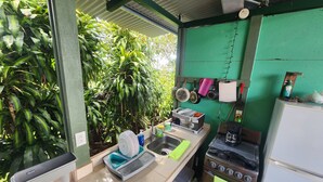 A compact kitchen with a sink, stove, and various utensils. - Ararat Eco Farm (Sabalito)