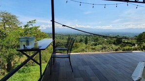 A patio with a table, chair, and a water container. - Ararat Eco Farm (Sabalito)