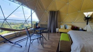 A tented accommodation with a dining area, a bed with pillows, and a view of the landscape. - Ararat Eco Farm (Sabalito)