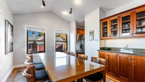 Une cuisine moderne avec des meubles en bois, un réfrigérateur en acier inoxydable et une grande table à manger.