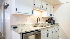 A kitchen with white cabinets, a stainless steel dishwasher, and a granite countertop. - Comfortable Eastside El Paso Home for Families, Nurses & Work Stays (El Paso)