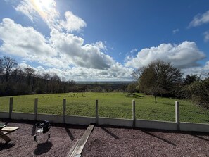 A grassy field with a fence, a barbecue grill, and a picnic table. - Charming cottage, Pays d'Auge. Near Cabourg & Dozulé (4km). High privacy. (Putot-en-Auge)