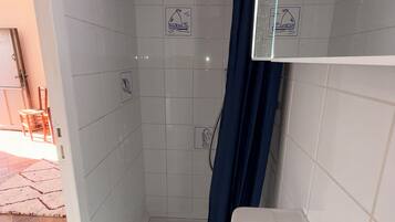 Een douche, handdoeken, zeep, toiletpapier