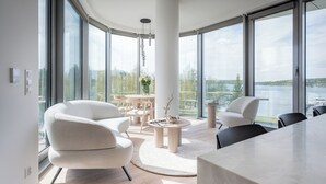 A modern living room with a large window, a round coffee table, and a white sofa. - Apartamenty Kapitańska by Elite4Rent (Olsztyn)