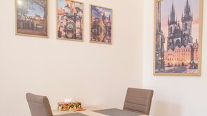Un comedor con una mesa, sillas, una caja de pañuelos y tres cuadros en la pared.