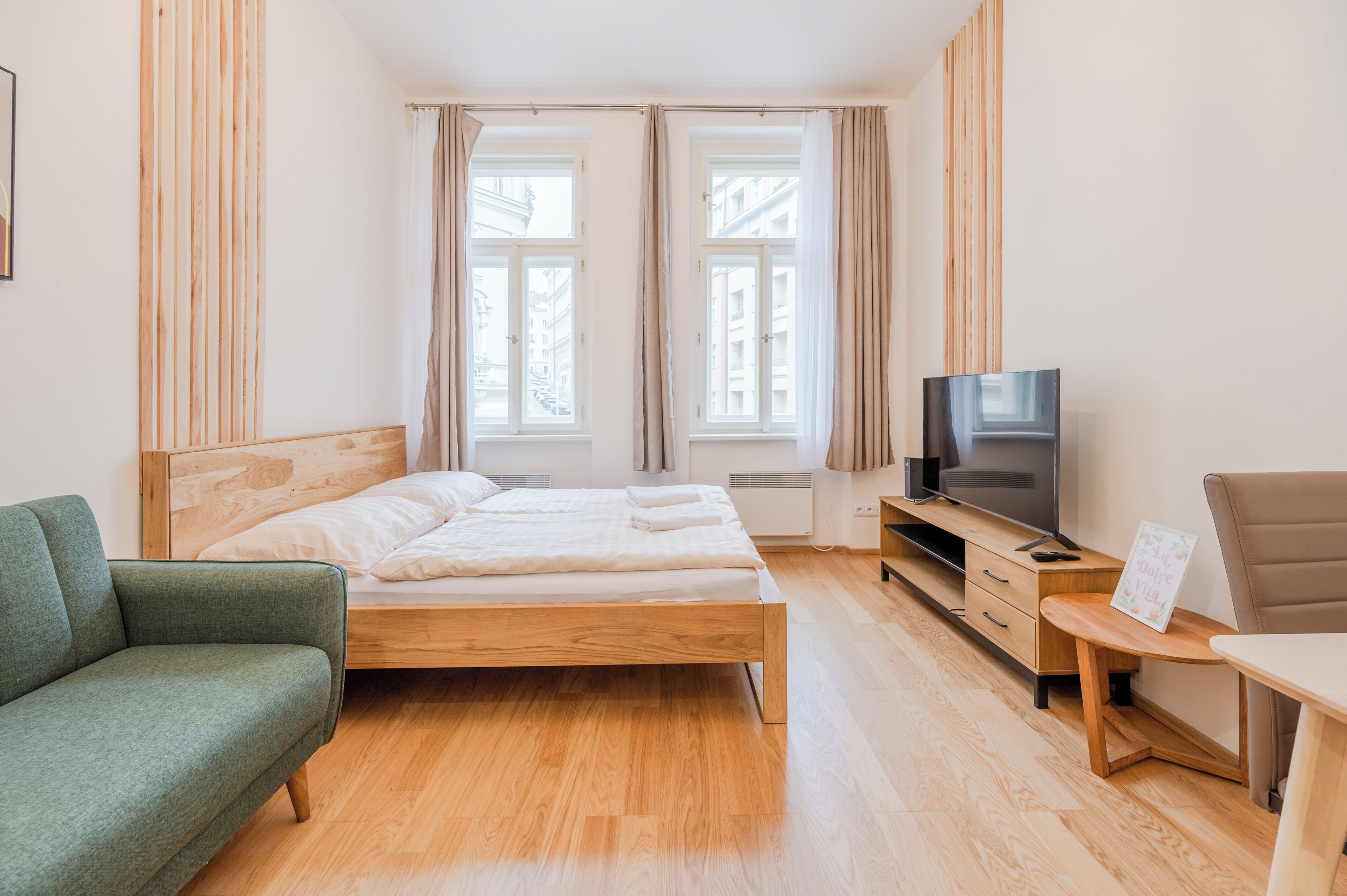Un dormitorio con cama, televisor, sofá y escritorio.